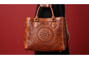Woman holding a handmade leather bag with intricate engraved design, showcasing custom leather engraving on handmade bags and accessories.